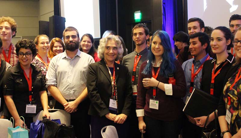 Dr. Persis Drell (center) surrounded by admiring physics students.