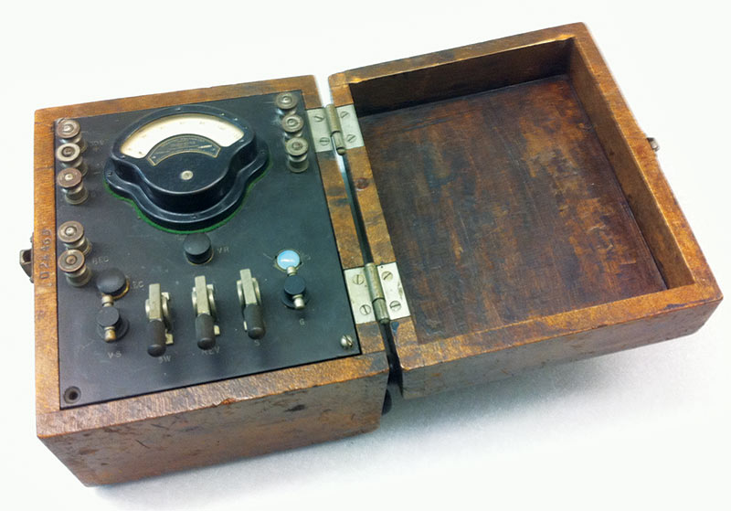 Antique test meter from an instrument collection at MIT, acquired by the school in the 1940s. The top center instrument is a miniature Weston voltmeter whose scale ranges from 0 to 120. The shape of the voltmeter is reflected in Sigma Pi Sigma’s insignia. 